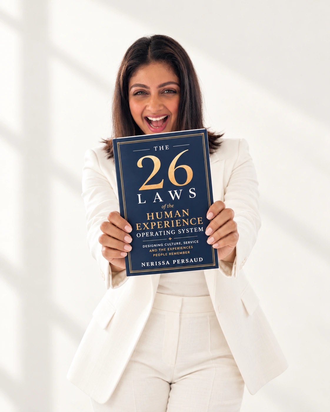Nerissa smiling and holding The 26 Laws towards the reader
